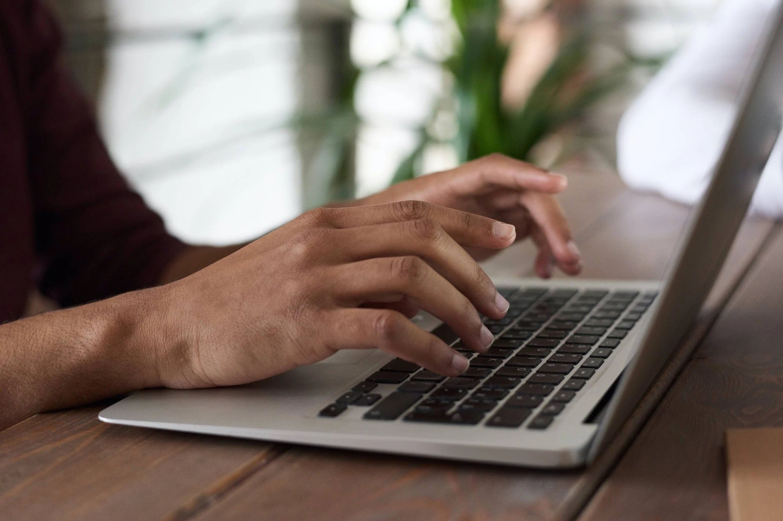 Closeup of hands typing on a laptop.