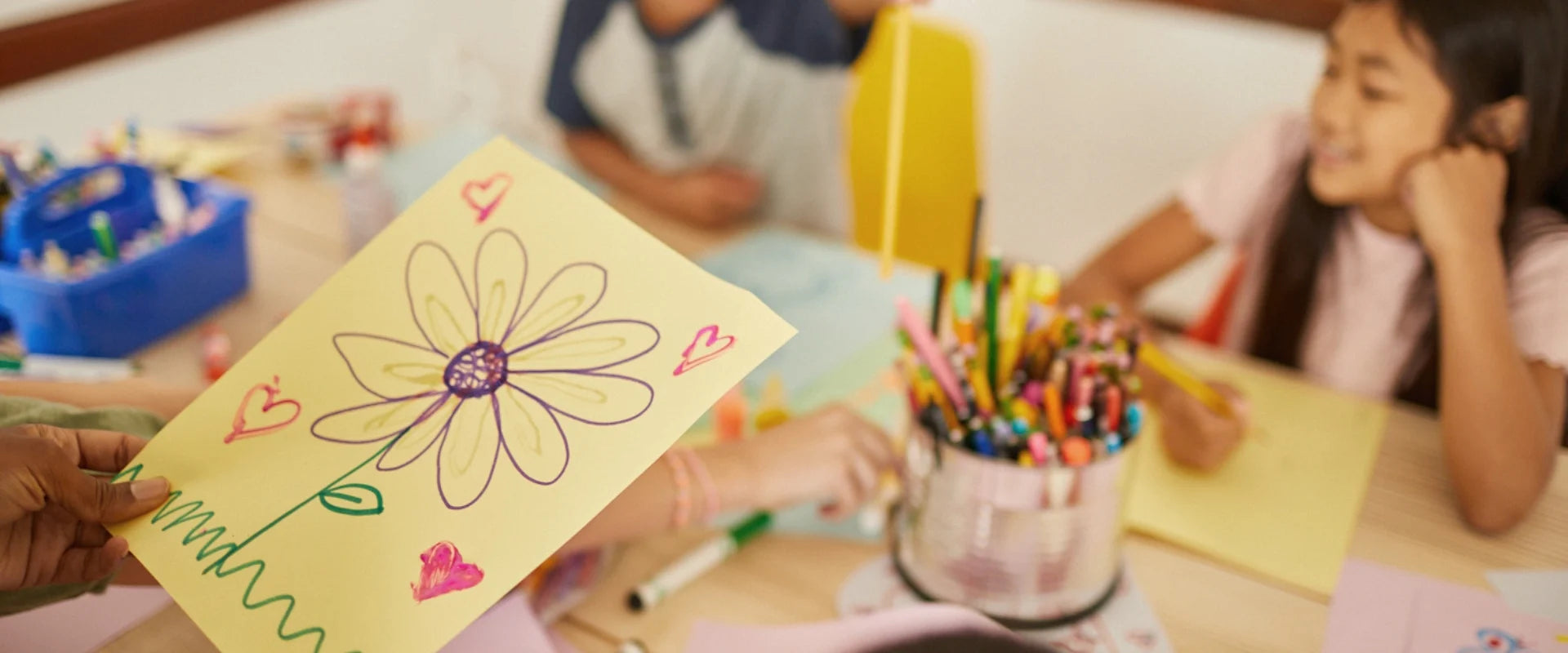 Kids a table working on crafts on color paper