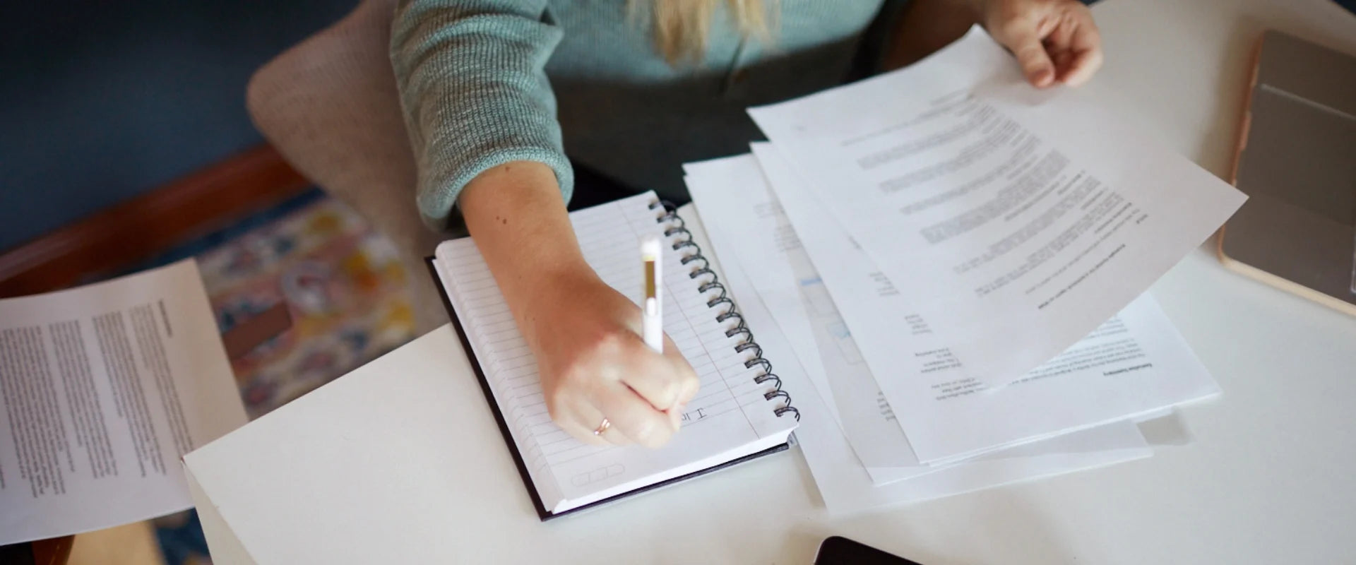 Woman at a desk writing in a notepad