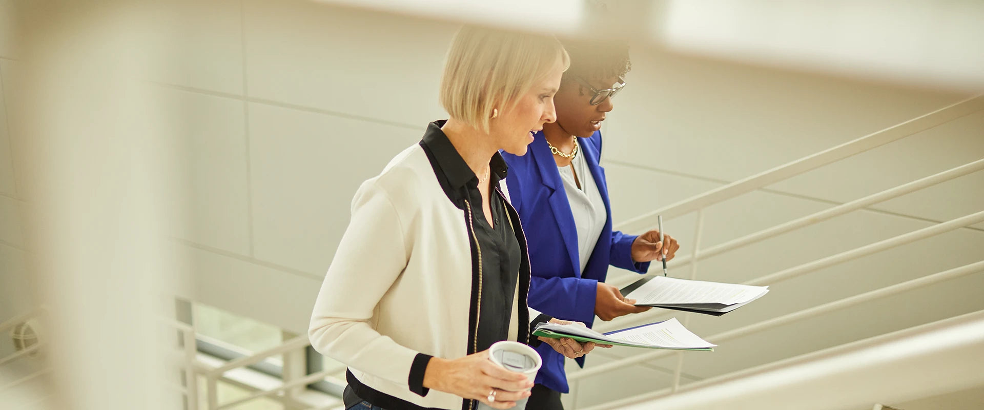 Two people in an office walking up the stairs.