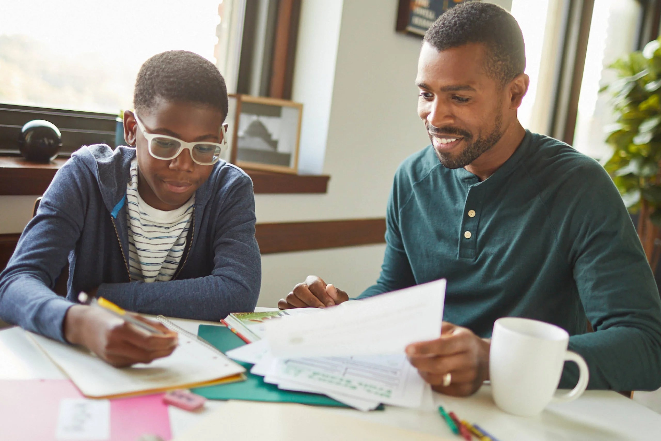 Dad and son doing schoolwork. 