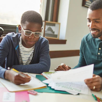Dad and son doing schoolwork. 