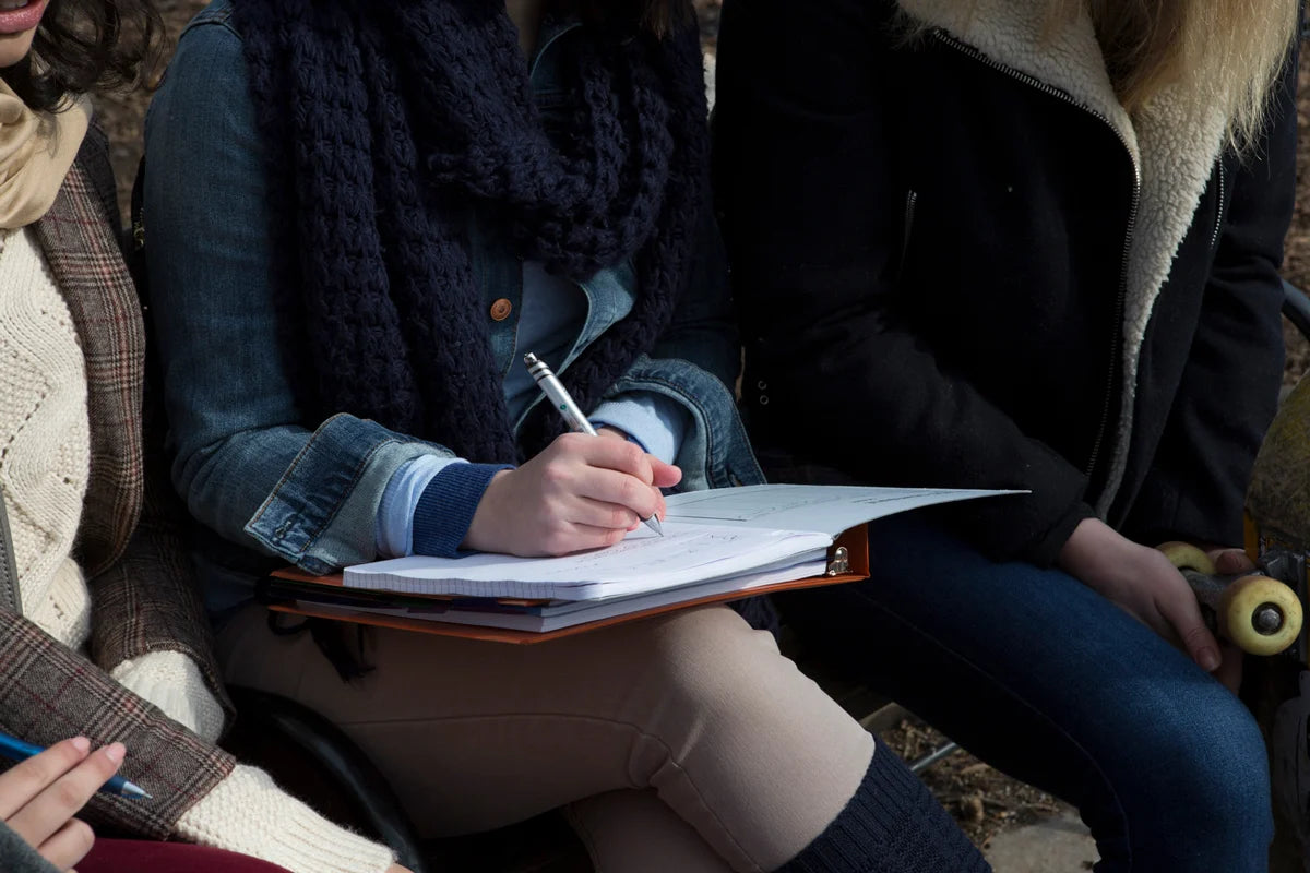 Person writing in a notebook.